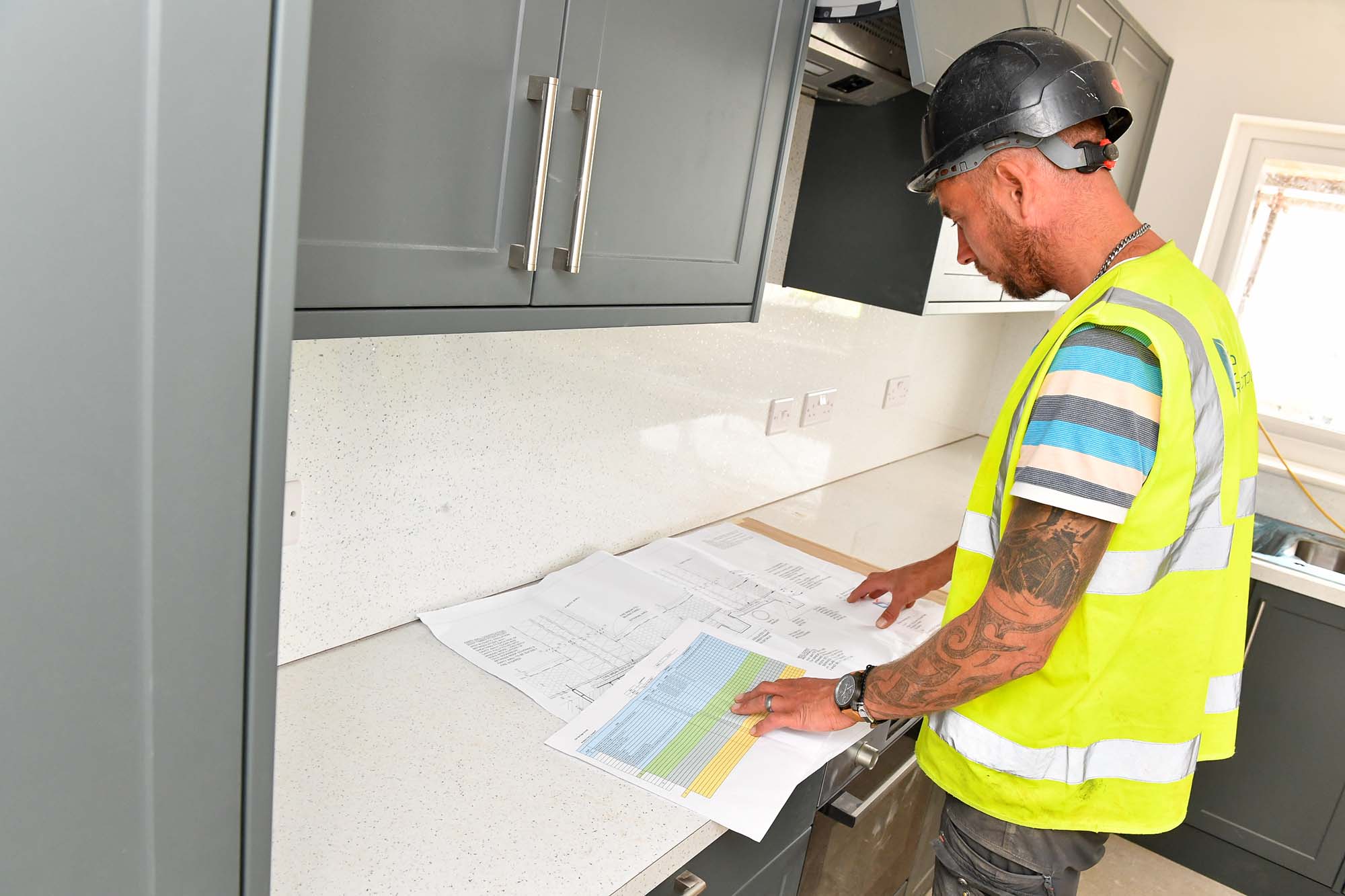 Customer Looking At Plans For New Kitchen